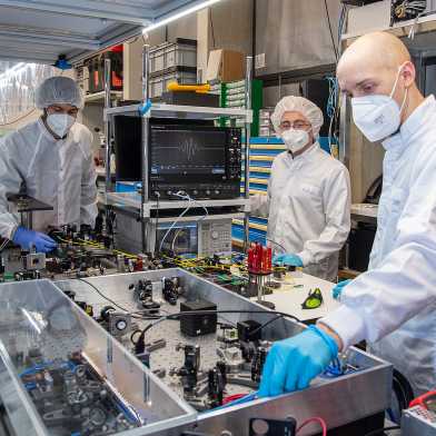 Team members Benjamin Willenberg, Justinas Pupeikis, and Christopher Phillips working with the dual-comb laser at the Ultrafast Laser Physics Lab