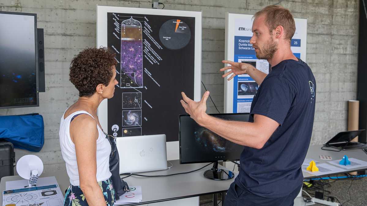 Doctoral student Dominik Züricher from Alexandre Refregier's research group explains the cosmological evolution of the universe to a visitor. 