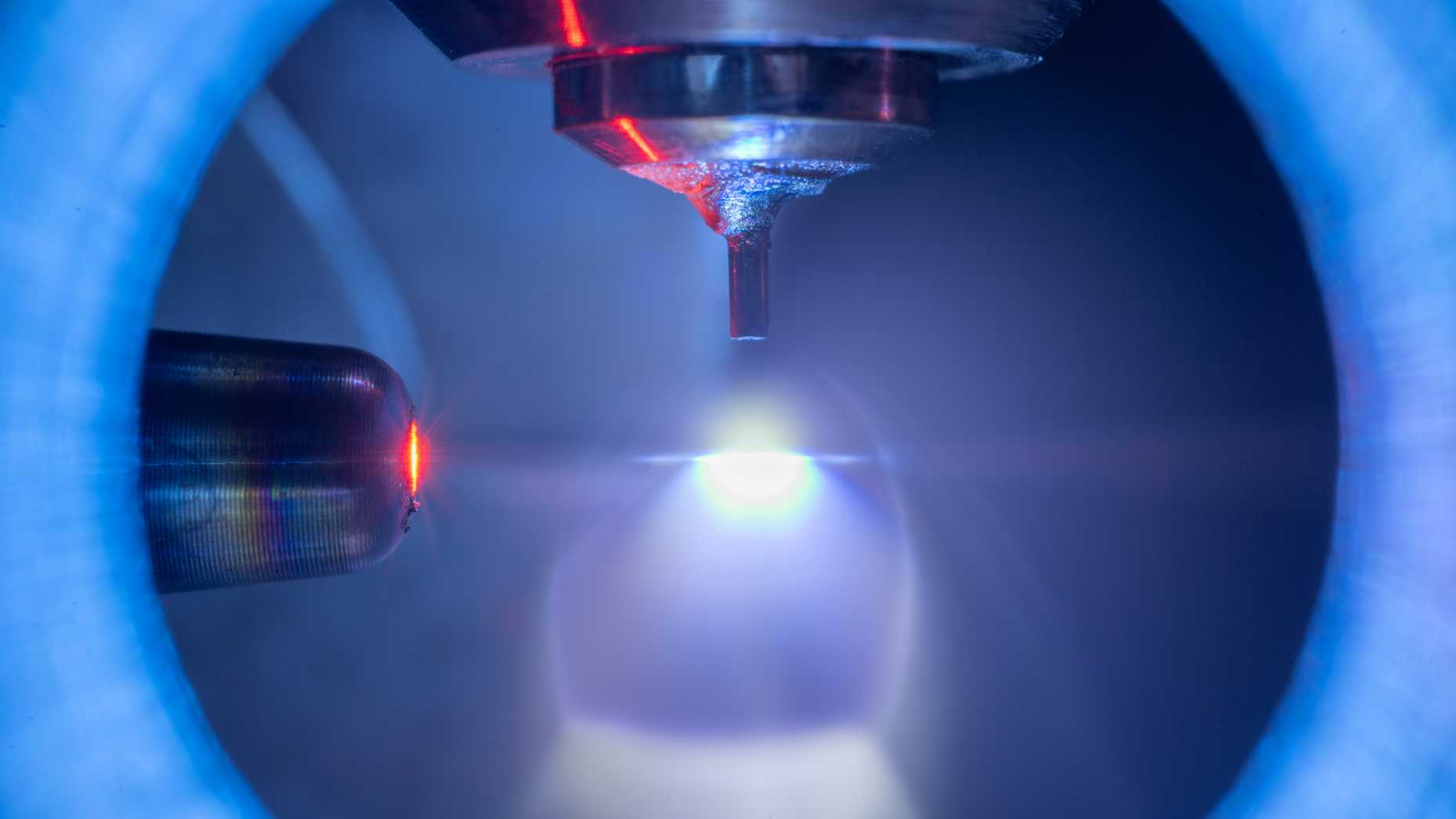 Foto des Experiments [1], bei dem Kryptonatome (Mitte) mit einem Hochleistungslaser (links) und weicher Röntgenstrahlung beleuchtet werden.