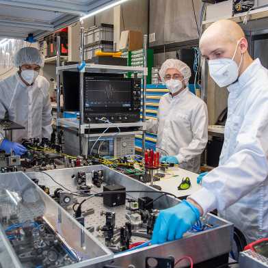 Team members Benjamin Willenberg, Justinas Pupeikis, and Christopher Phillips working with the dual-comb laser at the Ultrafast Laser Physics Lab