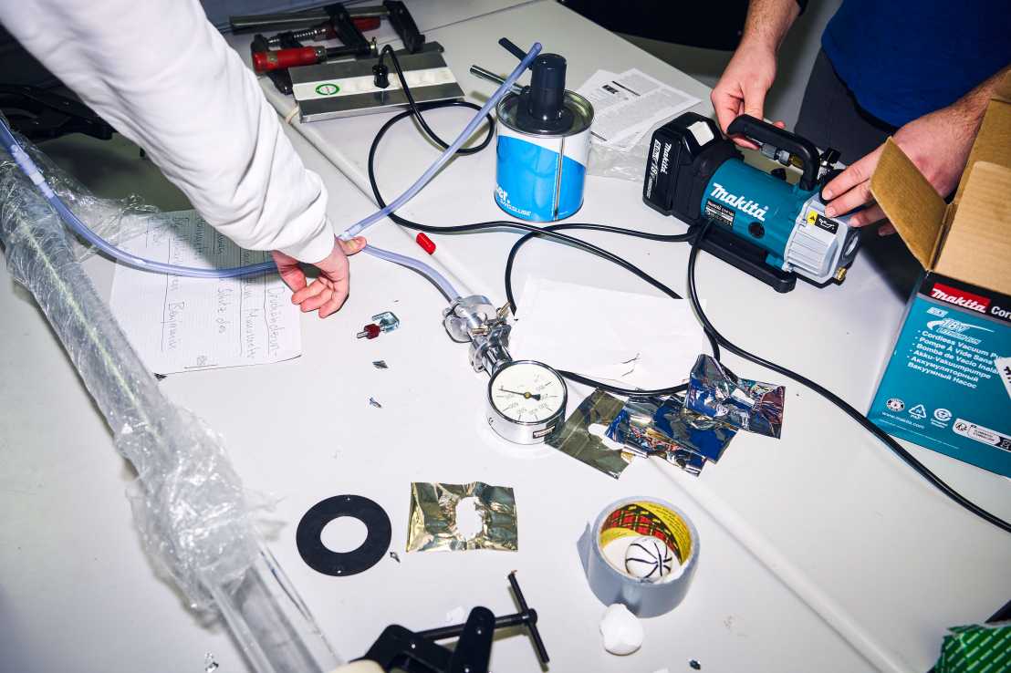 Enlarged view: A table in a workshop with hoses, compressor and tools
