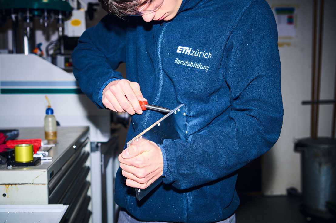 Enlarged view: An apprentice works on a metal part
